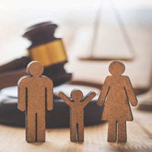 Wooden family model in front of a judge's gavel, symbolizing parental rights after divorce - Law Offices Of David Bliven