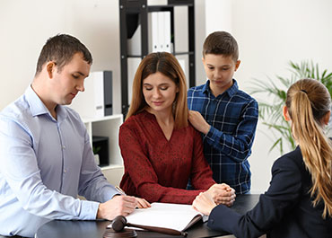 Family meeting with a lawyer to discuss and sign documents symbolizing Creating A Child Visitation Schedule