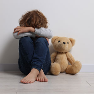 Sad child sitting with a teddy bear, symbolizing child neglect or abuse - Law Offices Of David Bliven